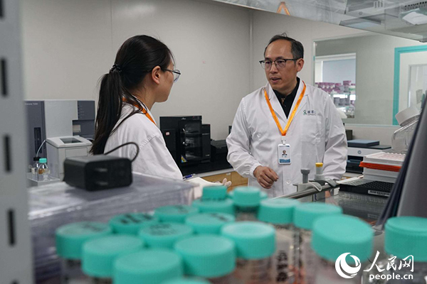 徐剛博士在實(shí)驗(yàn)室與工作人員交流。人民網(wǎng)記者 郝帥攝