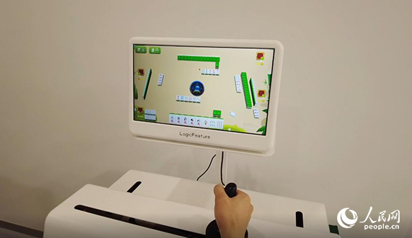 工作人員正在演示“運(yùn)動(dòng)-認(rèn)知康復(fù)機(jī)器人”。人民網(wǎng)記者 郝帥攝